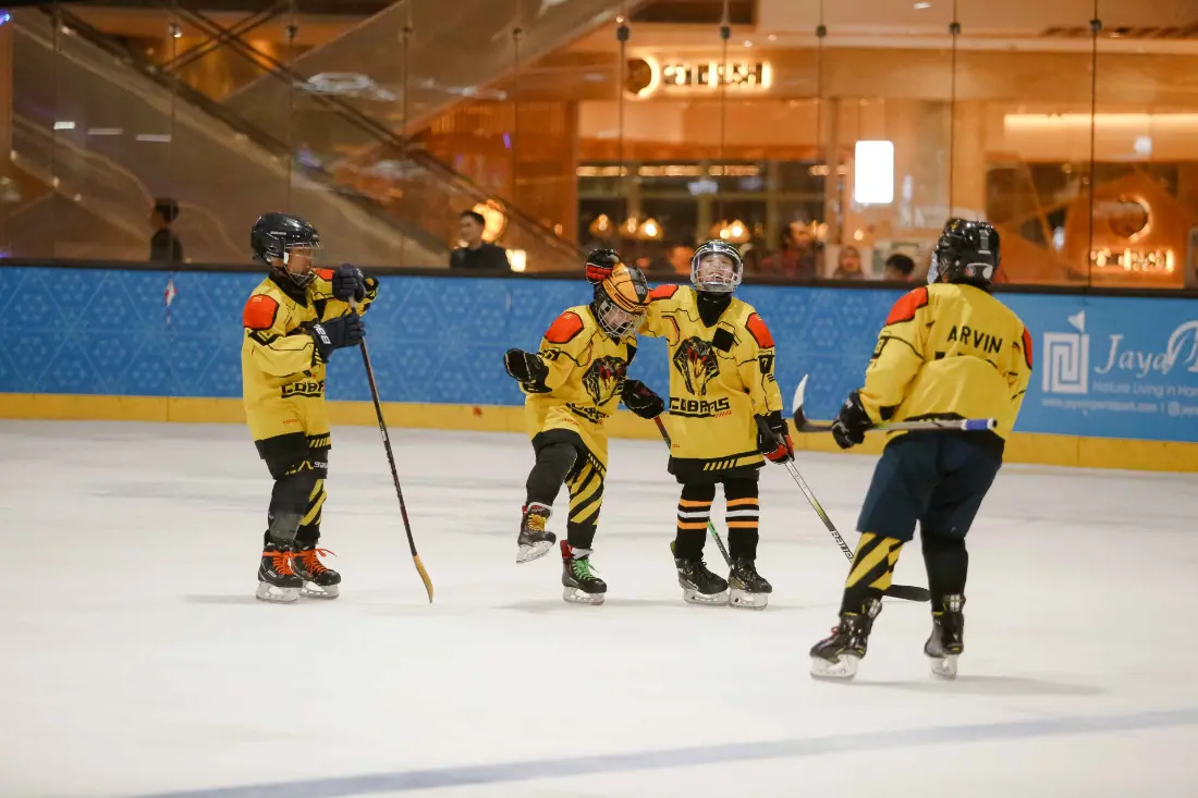 Young Golden Cobras players talking on the ice