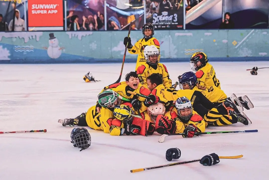 Golden Cobras players celebrating in a pile on the ice